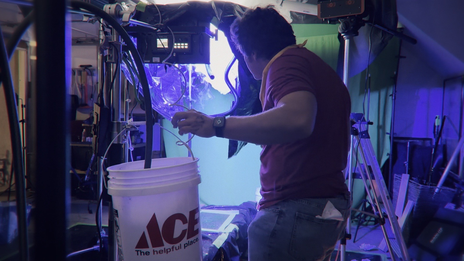 Burt connects the water and misting system around the lit miniature engine.